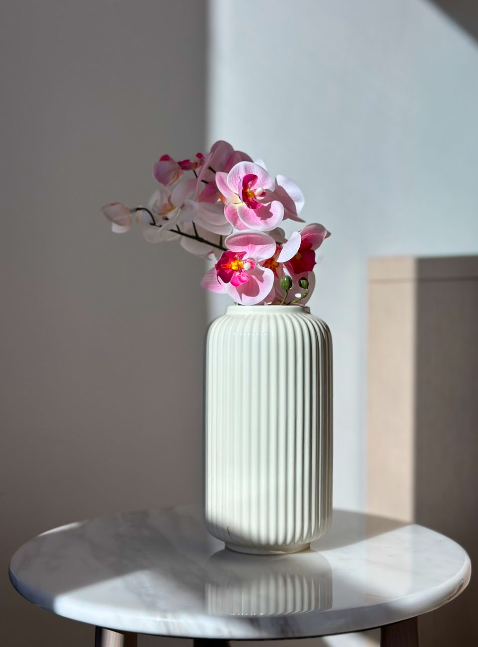 Pink orchids arranged in a modern vase